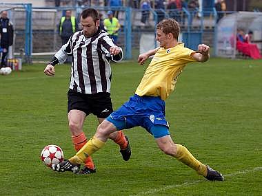 Benešovský David Zoubek (ve žlutém) vypichuje míč kolovečskému Tomáši Doškovi.  