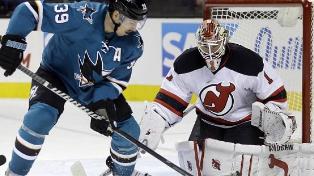 Logan Couture (San Jose Sharks) a gólman Keith Kinkaid (New Jersey Devils).
