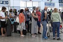 Cestující čekají na odbavení 1. července 2020 v hale Letiště Václava Havla v Praze