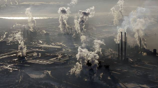 Letecký pohled na kouřící komíny ocelárny. Ilustrační snímek