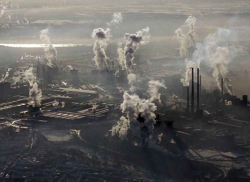 Letecký pohled na kouřící komíny ocelárny. Ilustrační snímek