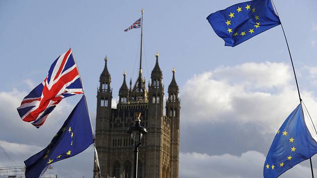 Vlajky EU a Británie, v pozadí budova britského parlamentu - ilustrační foto