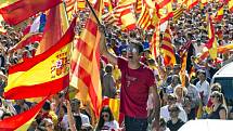 Lidé mávají španělskými i katalánskými vlajkami.