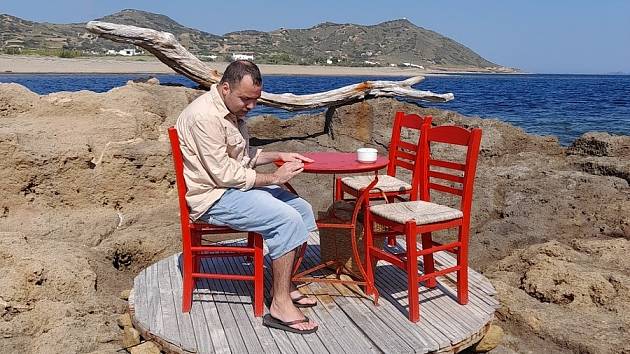Taverna s červenými židličkami na skyroské pláži Molos. Za přílivu k vám číšník musí po kolena ve vodě