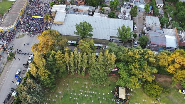 Příbuzní a přátelé pohřbívají rakev s ostatky Diega Maradony (vpravo). Vlevo nahoře policie zadržuje fanoušky před hřbitovem Jardín Bella Vista na předměstí Buenos Aires.