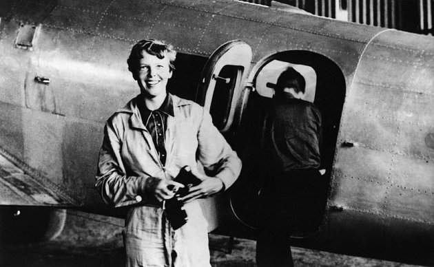 Slavná pilotka před letadlem Lockheed Electra, v němž se v roce 1937 pokusila spolu s Fredem Noonanem (zády ke kameře) neúspěšně o oblet Zeměkoule. Z této cesty se už nevrátila