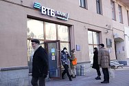 Lidé stojí ve frontě před bankou VTB v Moskvě, aby si vybrali peníze z bankomatu.