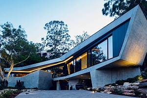 Konstrukce domu má netradiční podobu – je to podlouhlý bumerang kopírující tvar výklenku skály.