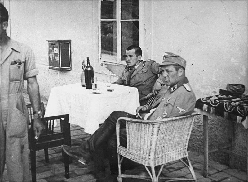 Vjekoslav Luburić sedící za stolem ve společnosti německého důstojníka