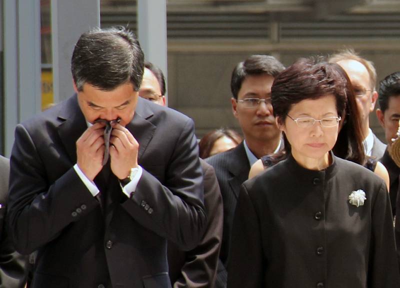 Šéf hongkongské exekutiv Leung Čchun-jing a hlavní tajemnice hongkongské administrativy Carrie Lamová truchlí nad oběťmi srážky trajektů