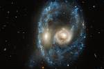Vypadá to jako strašidelná tvář plující vesmírem, ale ve skutečnosti snímek z Hubbleova dalekohledu zachycuje slučování dvou galaxií