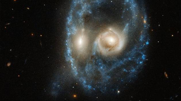 Vypadá to jako strašidelná tvář plující vesmírem, ale ve skutečnosti snímek z Hubbleova dalekohledu zachycuje slučování dvou galaxií