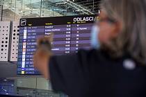 Turista sleduje odletovou tabuli na letišti ve Splitu