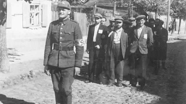 Litevský nacistický policista s židovskými vězni, červenec 1941