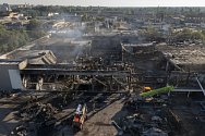 Hasiči prohledávají trosky nákupního střediska v ukrajinském Kremenčuku na snímku z 28. června 2022. Centrum o den dříve zasáhla ruská raketa.