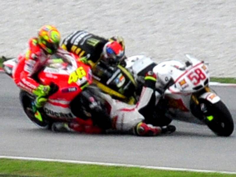  Valentino Rossi (vlevo) a Colin Edwards (uprostřed) naráží do Marca Simoncelliho, který havárii nepřežil.