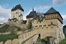 Architektonická perla – gotický hrad Karlštejn zdobí lesnatou krajinu Českého krasu.