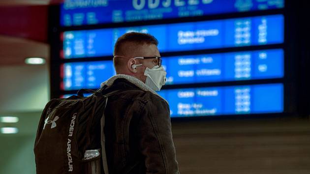 Muž s respirátorem stojí ve vestibulu Hlavního nádraží v Praze na snímku z 16. března 2020. Vláda zakázala volný pohyb lidí s výjimkou cest do zaměstnání, nezbytných cest za rodinou, pro základní životní potřeby nebo k lékaři.