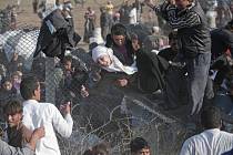 Syrští uprchlíci přelézají plot na hranicích s Tureckem