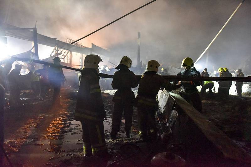 Hasiči likvidují požár nákupního centra v ukrajinském Kremenčuku.
