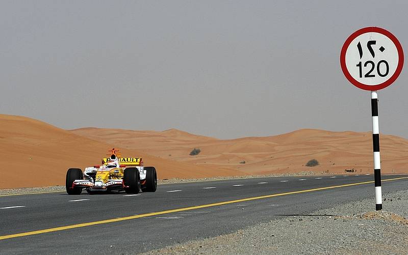 Romain Grosjean se prohání ve formuli 1 Renault po pouštní dálnici v Dubaji.