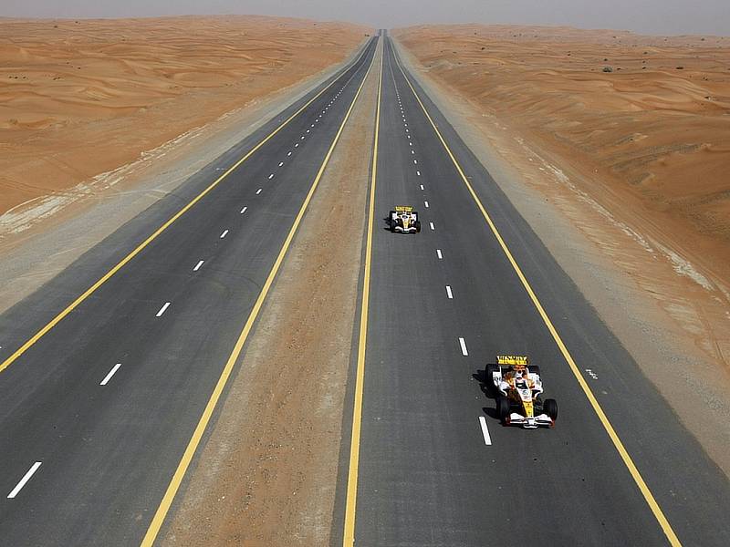 Romain Grosjean (vpředu) a Adam Khan se prohánějí ve formuli 1 Renault po pouštní dálnici v Dubaji.