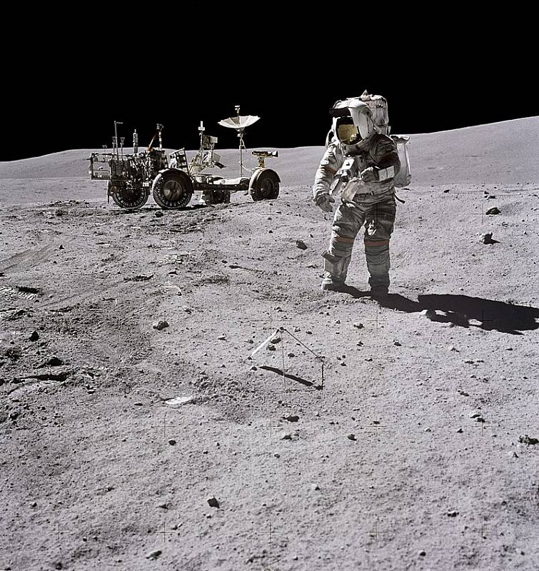 Velitel mise Apollo 16 John W. Young odebírá v třetí den pobytu na měsíčním povrchu vzorky hornin.
