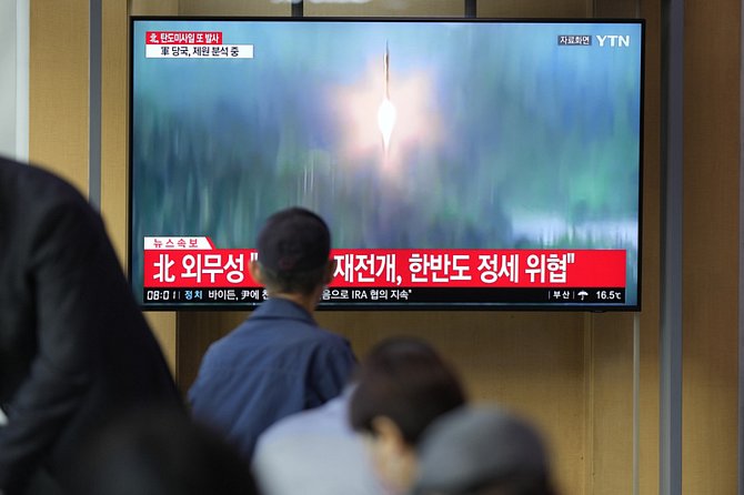 Lidé na vlakovém nádraží v jihokorejském Soulu sledují televizní reportáž o raketovém testu, který 6. října 2022 provedla KLDR.