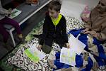 Chlapec, který se s rodinou po začátku invaze skrývá v kyjevském Krytu, ukazuje své obrázky.