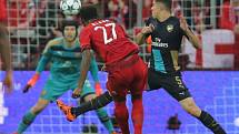 David Alaba z Bayernu Mnichov (v červeném) překonává brankáře Arsenalu Petra Čecha (v modrém).