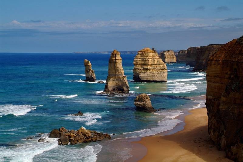 Přírodní útvar Dvanáct apoštolů lze najít u pobřeží Austrálie. Skal vystupujících z vody je ale ve skutečnosti už jen osm. Devátá se zřítila před několika lety. Její zbytky jsou vidět na fotce v popředí.
