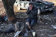 Snímky z Ukrajiny zachycují hrozivou realitu invaze. Ukrajinec na fotografii truchlí poblíž těla jiného muže (podle některých médií jeho syna) zabitého při ruském dělostřeleckém úderu na obytný dům ve městě Čuhujiv poblíž Charkova.
