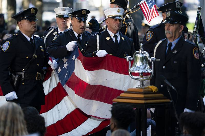 Památeční vlajka je přinášena na pódium během piety na památku obětí teroristických útoků 11. září 2001