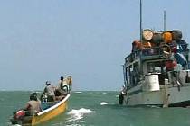 Piráti na člunu vedle svého mateřského plavidla u somálského přístavu Eyl.