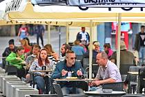Lidé sedí 11. května 2020 na zahrádce jedné z restaurací v centru Brna. Po přestávce vynucené šířením nového typu koronaviru mohly restaurace a kavárny otevřít své předzahrádky, za další dva týdny otevřou i vnitřní prostory.