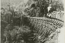 Vlak na dřevěném železničním mostě na 155. kilometru barmsko-thajské železnice mezi Tampi a Hintoku v Thajsku