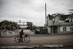 Muž na kole projíždějící mezi domy zničenými při bojích mezi Rusy a Ukrajinci při osvobozování města Balaklija v Charkovské oblasti