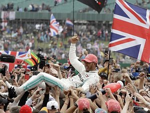 Britský jezdec Mercedesu Lewis Hamilton oslavuje vítězství ve Velké ceně Británie Formule 1 na okruhu v Silverstone.