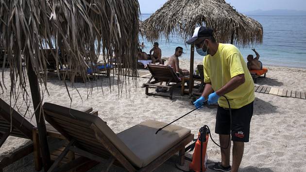 Dezinfikování lehátek na pláži v Řecku