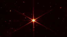 Testovací snímek pořízený Webovým teleskopem. Jeho snímací senzory jsou natolik citlivé, že kromě hvězdy, na kterou se měl zaměřit, zachytil i galaxie a hvězdy v pozadí.