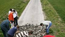 Studenti z Raismes strhávají nový povrch silnice z trasy závodu.