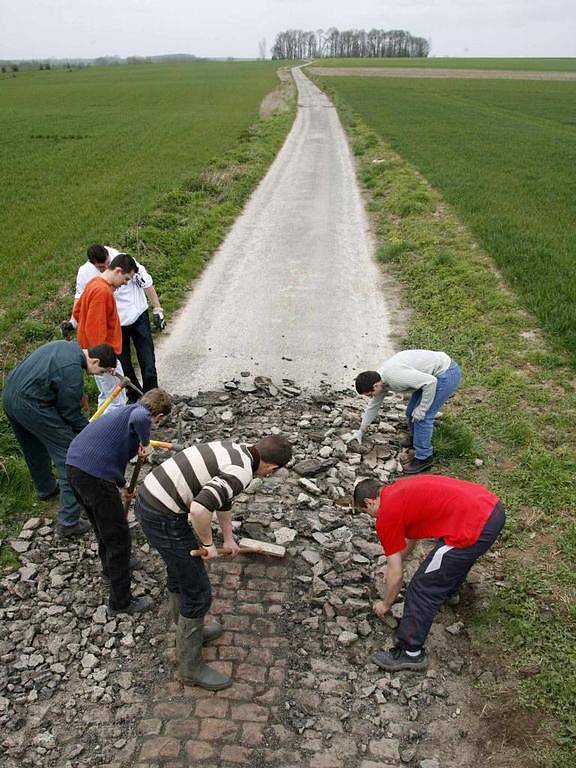 Studenti z Raismes strhávají nový povrch silnice z trasy závodu.