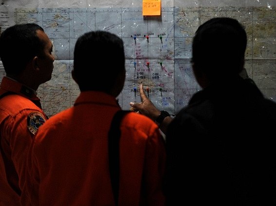 Záchranáři se radí nad mapou území, kde se ztratilo letadlo společnosti Indonesia AirAsia. 
