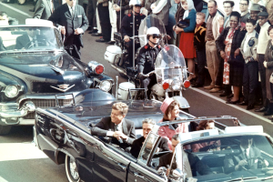 Prezidentská limuzína Johna F. Kennedyho v texaském Dallasu na Main Street, jen pár minut před atentátem. V limuzíně jeli také Jackie Kennedyová, texaský guvernér John Connally a jeho žena Nellie.