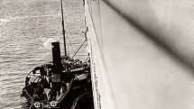 Vlečný člun America uvázaný po boku Titaniku, snímek Francise Brownea z paluby lodi