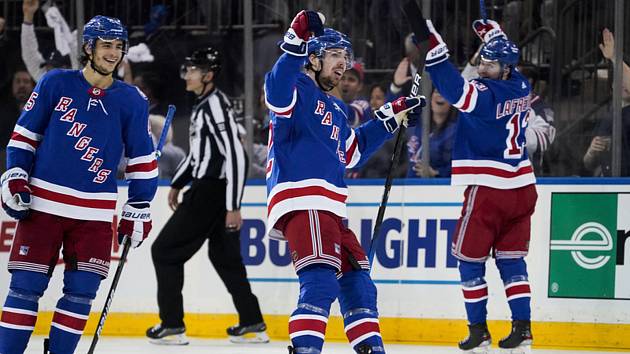 Filip Chytil (uprostřed) z Rangers se raduje po svém gólu do sítě Caroliny v šestém zápase druhého kola play off NHL.