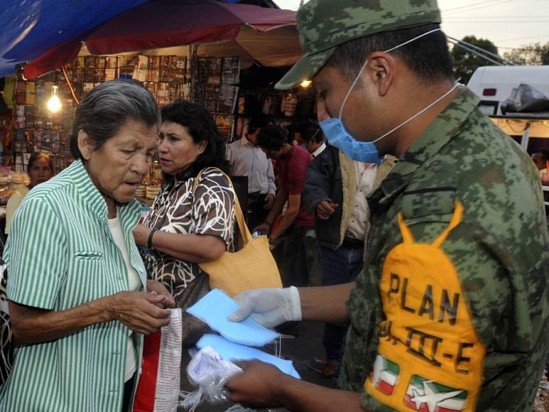 Policisté v ulicích Mexico City rozdávají instrukce a ochranné masky.