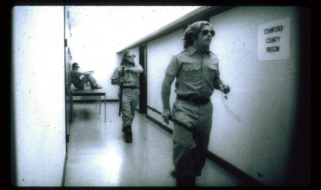 Záběr ze stanfordského vězeňského experimentu, který vykonal psycholog Philip Zimbardo. Studenti, kteří představovali dozorce, kráčí po chodbě experimentálního vězení.