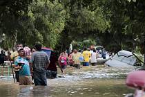 Lidé se ve městě Planeta brodí po ulicích zaplavených po řádění hurikánu Eta.