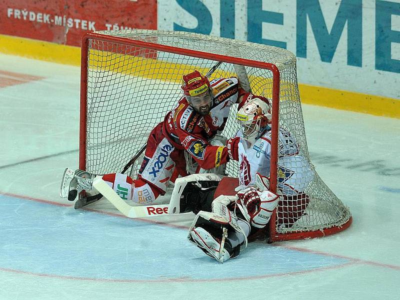 Gólman Třince Peter Hamerlík (vpravo) v brance s hokejistou Slavie.